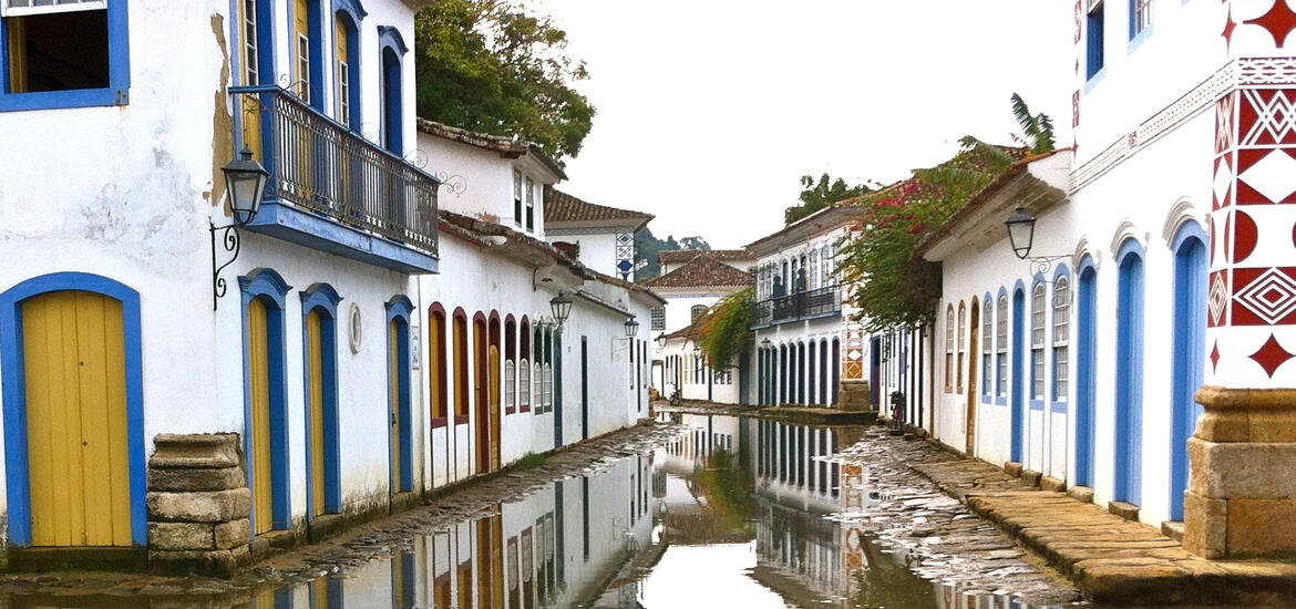 Low, white buildings lining a canal in Paraty, Brazil.