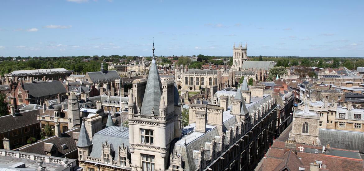 An aerial view of historic buildings and rooftops in Cambridge, featuring Gothic and medieval architecture 