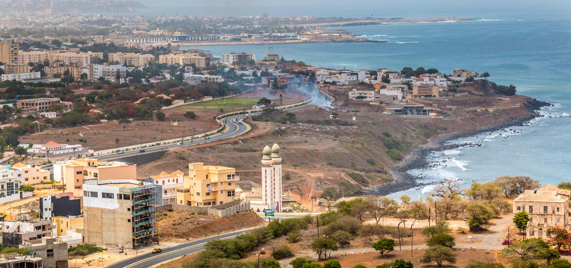 An aerial view of Dakar, Senegal, with buildings along the coastline and the Atlantic Ocean in the background