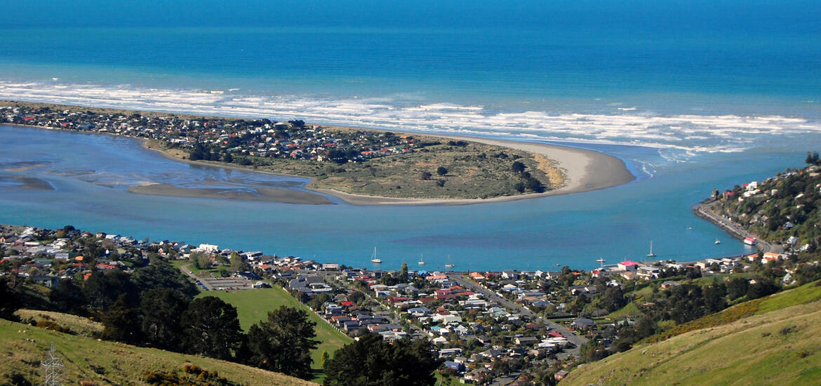 An aerial view of Southside Beach in Christchurch, New Zealand, showing the coastline, a riverbend, and residential areas