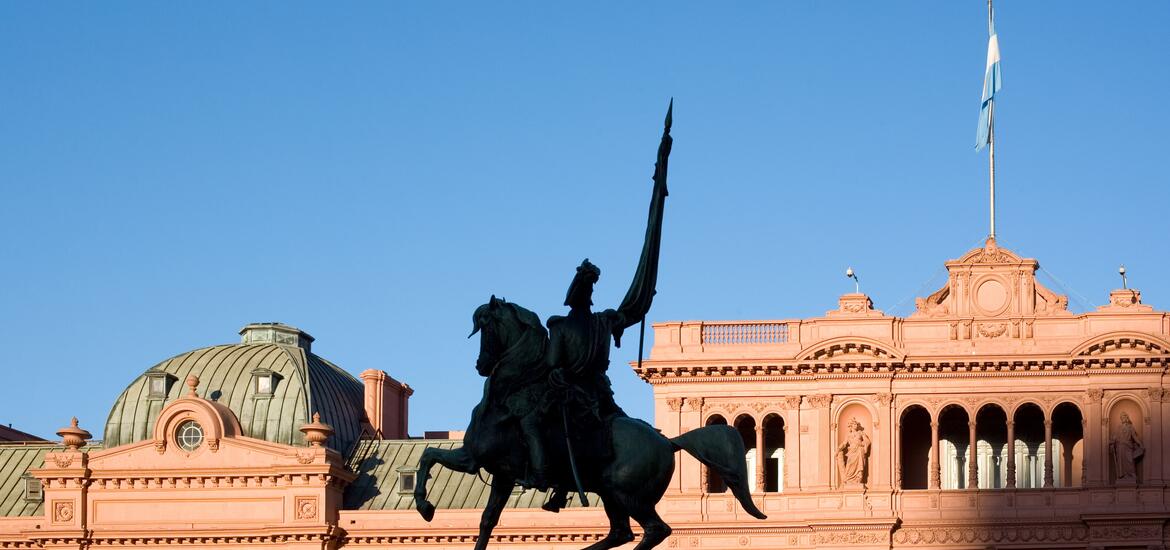 Silhouette of the General Belgrano Monument on horseback, with the historic Casa Rosada, the presidential palace of Argentina, in the background