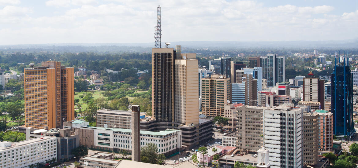 An aerial view of Nairobi, Kenya, featuring modern high-rise buildings, surrounded by greenery