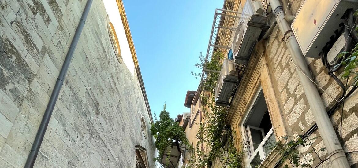 A panoramic view of buildings with red roofs and an island in the background, taken from the city walls of Dubrovnik