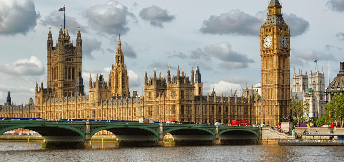 A view of Big Ben and the Houses of Parliament in London under cloudy skies, with Westminster Bridge in the foreground 