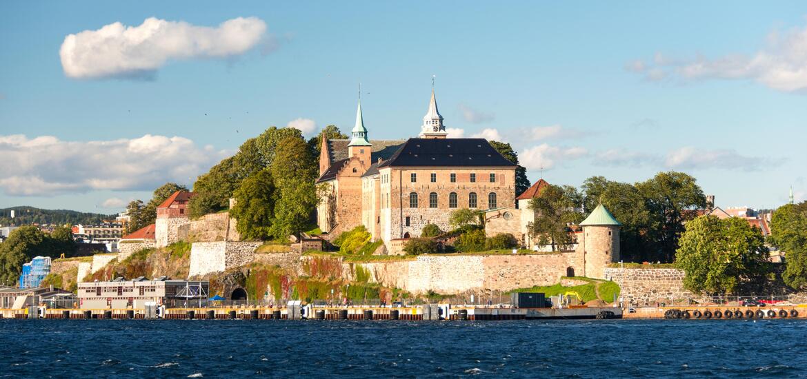 A view of Akershus Fortress in Oslo, Norway, with its historic stone walls and towers overlooking the waterfront