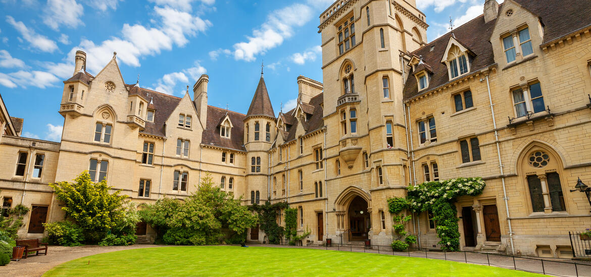 The courtyard of Balliol College at Oxford University, surrounded by charming, historic stone buildings with towers and pointed rooftops 