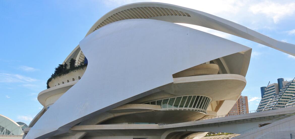 The stone ruins of a castle stand on a hilltop surrounded by mountains.