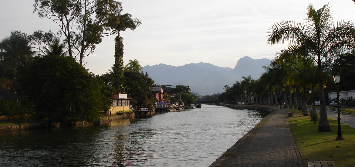 Low, white buildings lining a canal in Paraty, Brazil.
