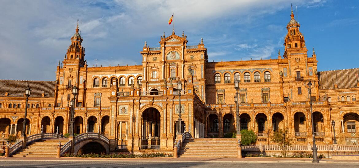 The grand facade of Plaza de España in Seville, featuring its elegant arches, towers, and intricate architectural details