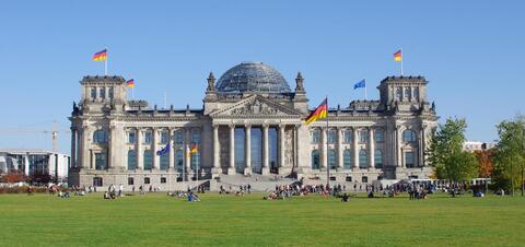 Tourists on the lawn of the Reichstag Building in Berlin, Germany