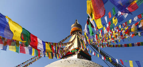 The Bodhnath Stupa in Kathmandu, Nepal, adorned with colorful prayer flags