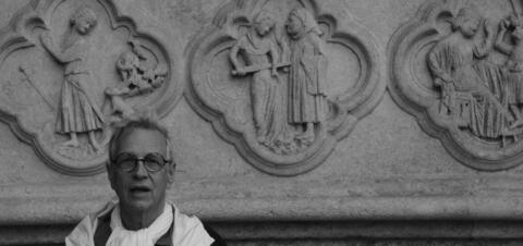 In front of the Cathedral of Amiens (Photo by John Lee, Berkeley College '18) A person stands in front of detailed stone carvings depicting religious scenes on the wall of the Cathedral of Amiens