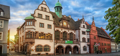 On old brown stone and plaster building in Freiburg, Germany at sunrise