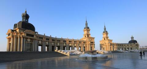 A view of the grand buildings at Harbin Music Park in Qunli District, Harbin, with ornate domes and spires against a blue sky