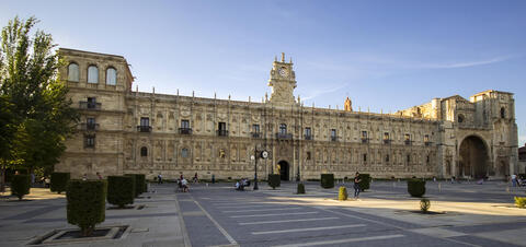 A view of the Convent of San Marcos in León, featuring its ornate Renaissance facade, intricate architectural details, and central clock tower 